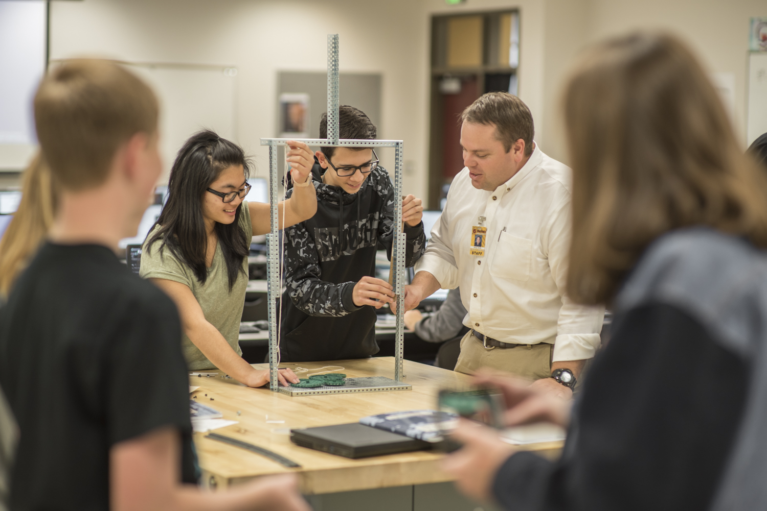 Two students showing off their tech build to their teacher