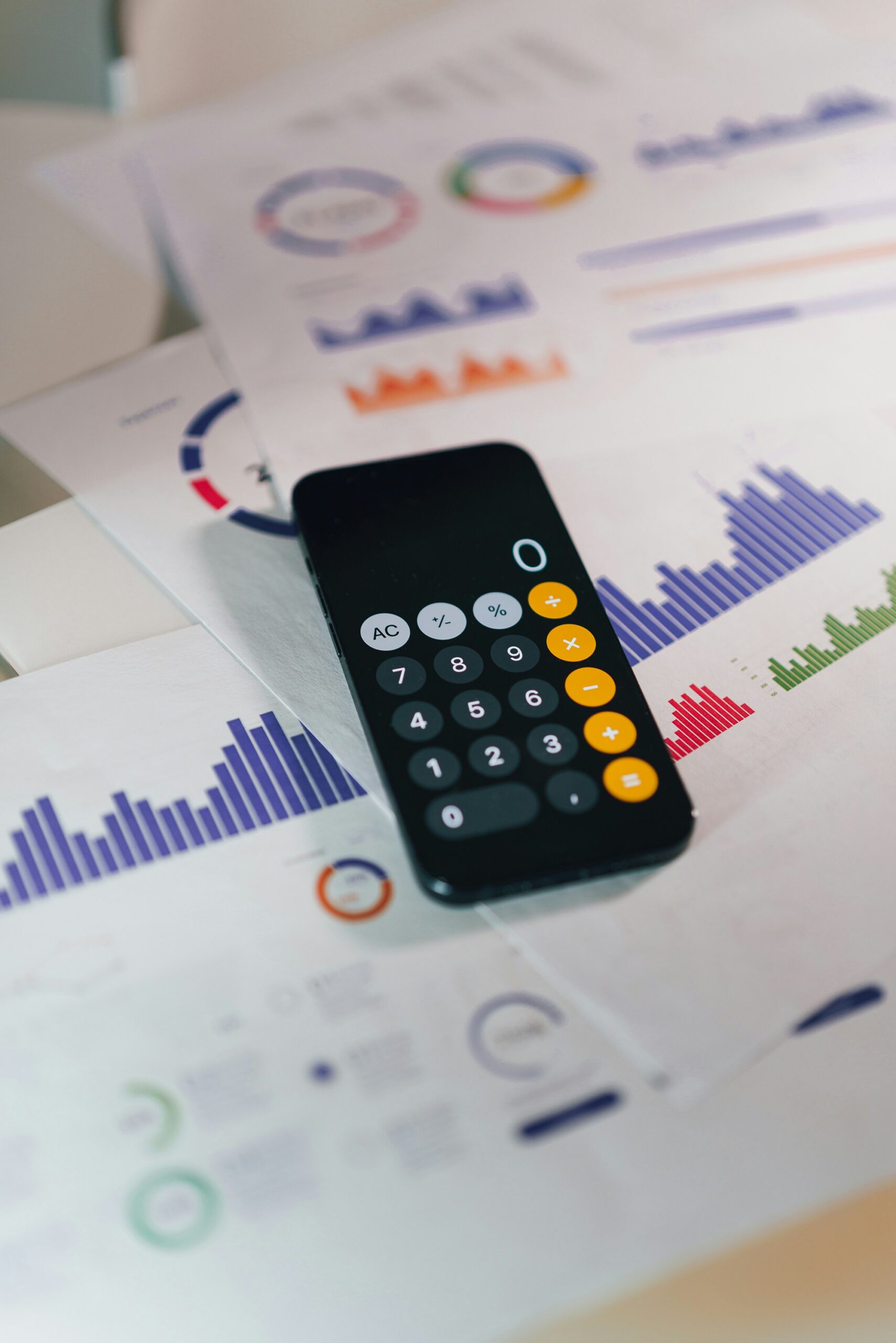 calculator lying on top of financial reports