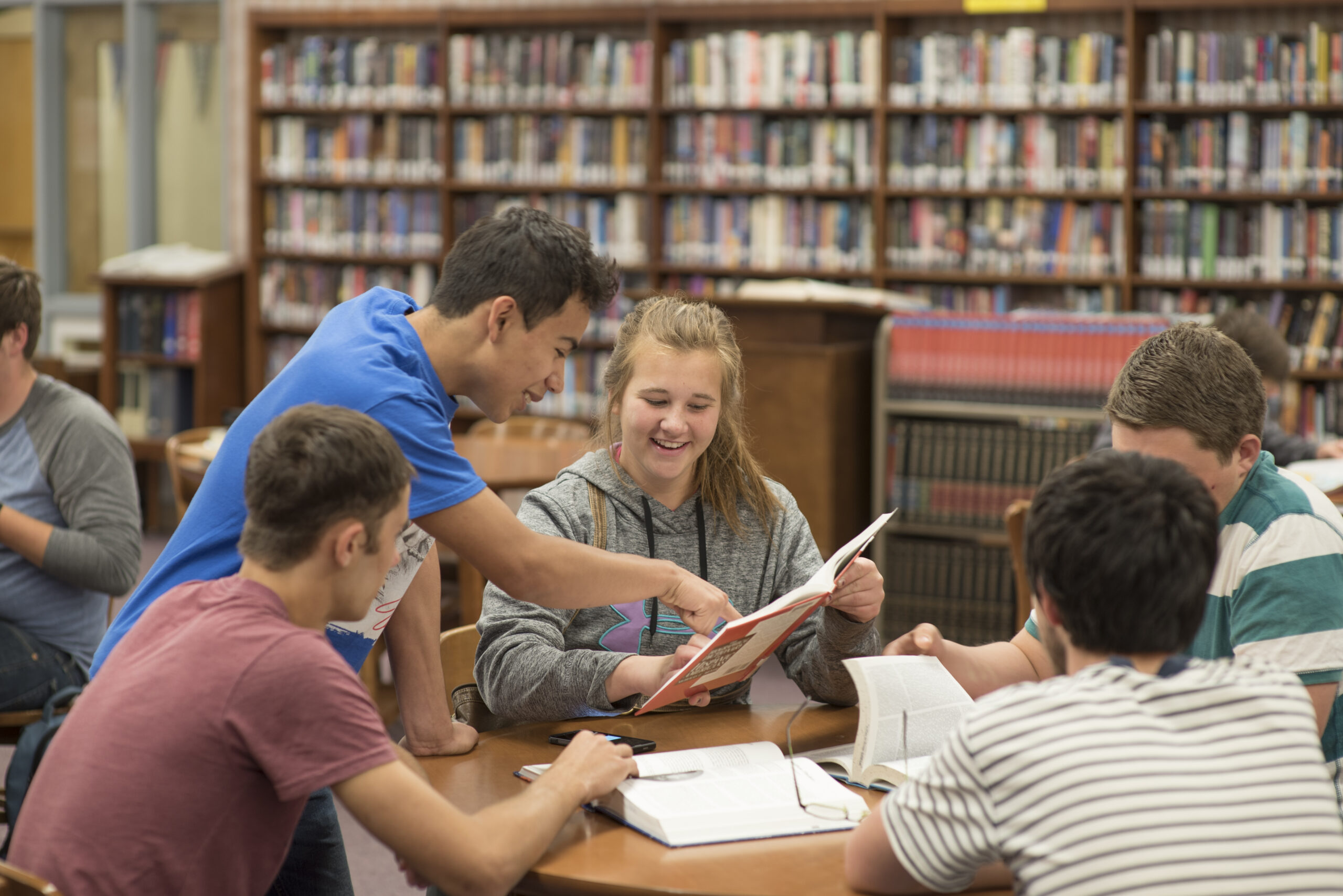 A group of students looking together at an image in a book