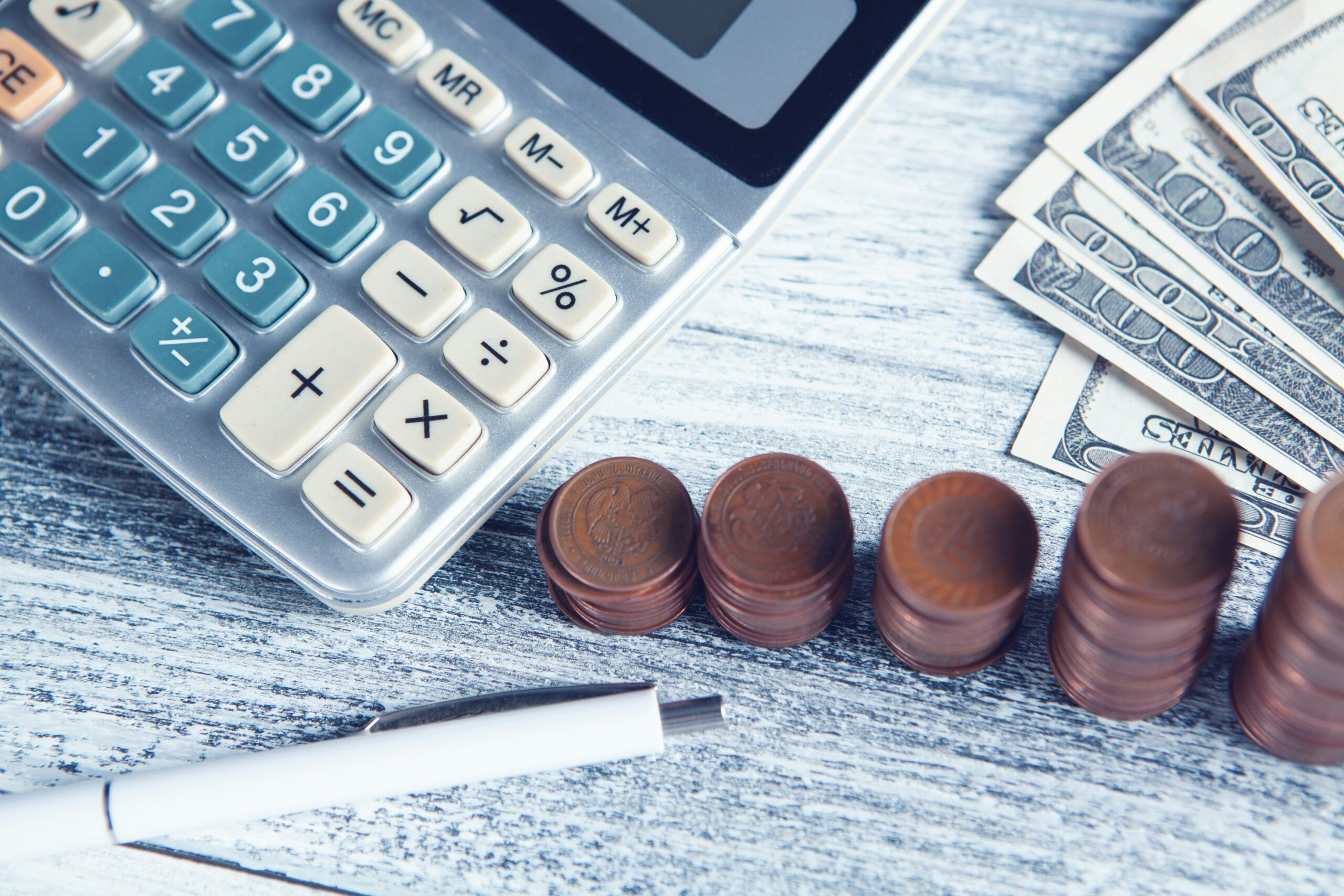 calculator, coins, paper money and a pen