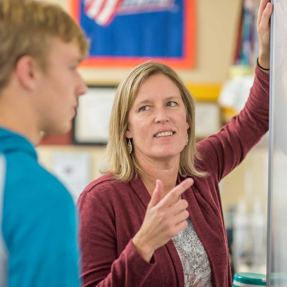 teacher working one-on-one with a high school student