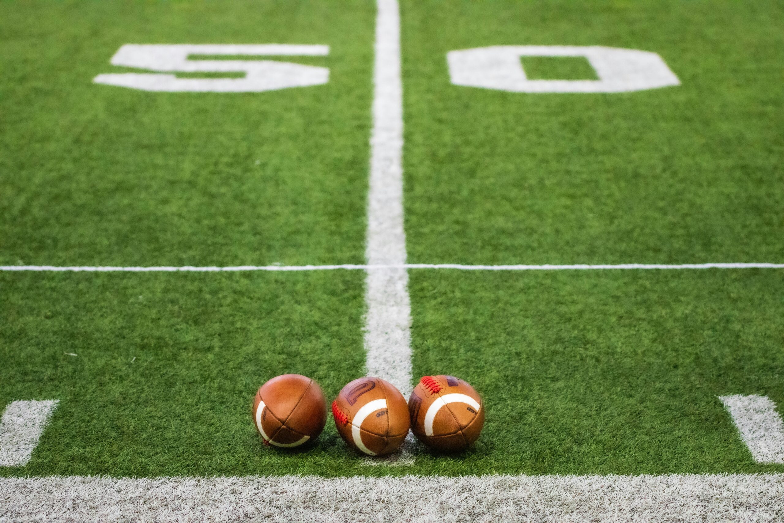 three footballs on the 50-yard line
